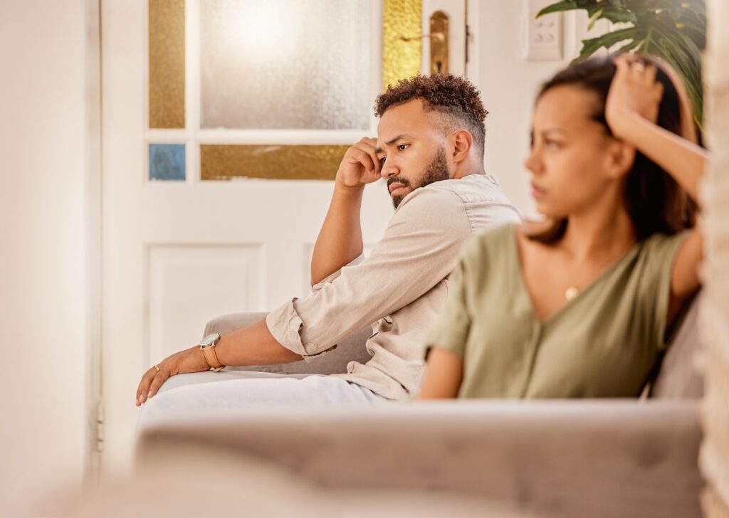 angry couple on living room sofa in house