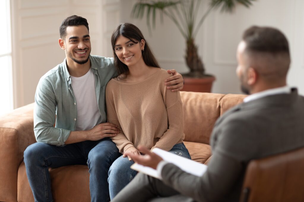 happy couple recounciling at therapy session with therapist