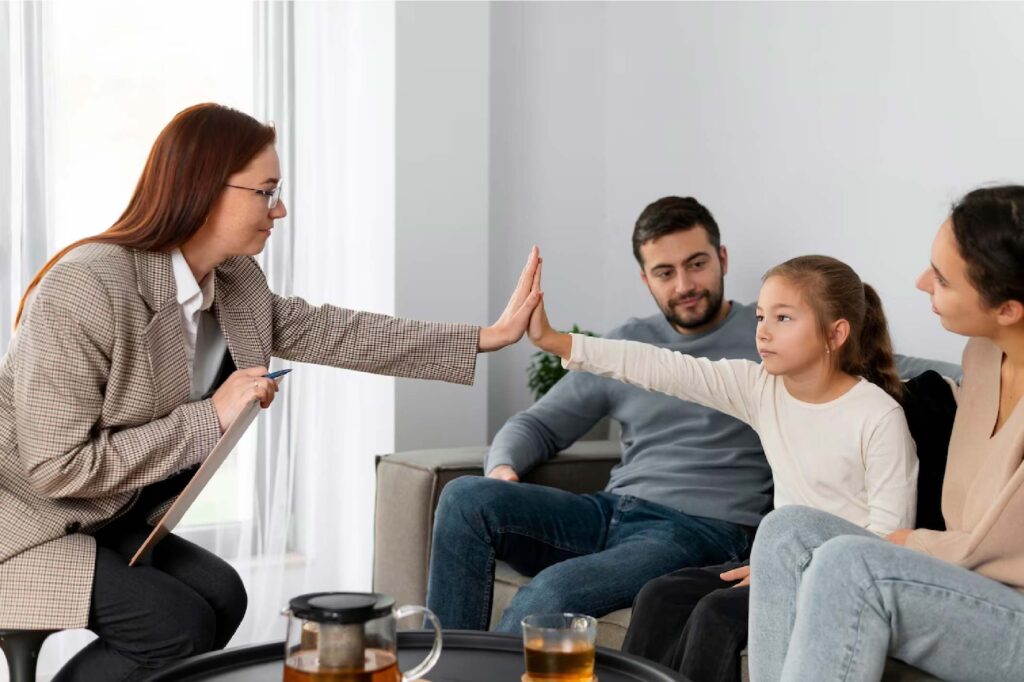 Therapist holding hand with child at therapy session with the couple