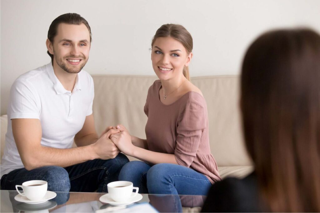 couple holding hands at therapy session with their therapist
